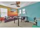 Colorful living room with a purple sofa, accent wall, and ceiling fan at 29740 W Fairmount Ave, Buckeye, AZ 85396