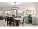 Elegant dining area featuring a modern light fixture, a view to the outdoors, and a stylish cabinet for storage at 3034 E Coconino Dr, Gilbert, AZ 85298