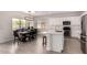 Modern open kitchen with a dining area featuring white cabinets, stainless steel appliances, and a stylish island at 3034 E Coconino Dr, Gilbert, AZ 85298