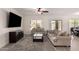 Bright living room featuring neutral walls, a ceiling fan, a decorative rug, and sliding glass doors to the backyard at 3034 E Coconino Dr, Gilbert, AZ 85298