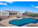 Aerial view of a backyard with a pool, patio, and a well maintained lawn surrounded by gravel at 30488 N 126Th Dr, Peoria, AZ 85383