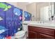 Bright bathroom featuring a vibrant ocean-themed shower curtain and a white vanity at 30488 N 126Th Dr, Peoria, AZ 85383