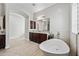 Bright bathroom featuring a modern soaking tub, wood cabinets, and marble countertops at 30488 N 126Th Dr, Peoria, AZ 85383