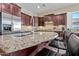 Granite island with stainless steel appliances, dark wood cabinets, and bar seating at 30488 N 126Th Dr, Peoria, AZ 85383