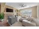 Bright living room boasts fireplace, large sectional, and a fan, creating an inviting and comfortable atmosphere at 30488 N 126Th Dr, Peoria, AZ 85383