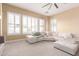 Bright living room featuring shuttered windows and a large sectional sofa with throw pillows and blankets at 30488 N 126Th Dr, Peoria, AZ 85383