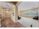 Open-concept living room with neutral carpet, arched doorways, and large windows, creating a bright and airy atmosphere at 30488 N 126Th Dr, Peoria, AZ 85383