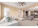 Inviting living room with neutral colors, comfortable seating, and a view into the kitchen and dining area at 30488 N 126Th Dr, Peoria, AZ 85383