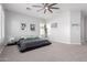 Spacious main bedroom with a platform bed, light gray walls, neutral carpet, and a modern ceiling fan at 30488 N 126Th Dr, Peoria, AZ 85383