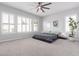 Main bedroom with neutral colors, shuttered windows, and a large bed on a platform at 30488 N 126Th Dr, Peoria, AZ 85383