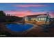 Gorgeous backyard featuring a serene pool reflecting the warm glow of the evening sky, with lounge seating at 30488 N 126Th Dr, Peoria, AZ 85383