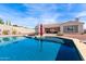 Inviting backyard pool with lounge chairs, umbrella, and desert landscaping creating a perfect retreat at 30488 N 126Th Dr, Peoria, AZ 85383