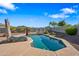 Backyard pool featuring lounge chairs and patio umbrella, surrounded by gravel and plants at 30488 N 126Th Dr, Peoria, AZ 85383