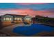 Stunning backyard with a sparkling pool reflecting the colorful sunset sky, and a covered patio at 30488 N 126Th Dr, Peoria, AZ 85383