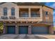 Exterior view of the home highlighting the three-car garage, stone accents, and private balcony at 320 N 168Th Dr, Goodyear, AZ 85338