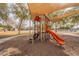 Community playground with colorful equipment, a shaded play area, and soft ground cover at 320 N 168Th Dr, Goodyear, AZ 85338