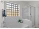 Modern bathroom featuring a tub, shower, and natural light through a block window at 3746 E Vallejo Dr, Gilbert, AZ 85298