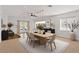 Modern dining room featuring a long, light wood table, stylish seating, and elegant pendant lighting at 3746 E Vallejo Dr, Gilbert, AZ 85298