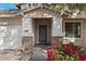 Close-up of home's entrance with stone accents on columns, bougainvillea and a well-manicured lawn at 3746 E Vallejo Dr, Gilbert, AZ 85298