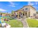 Beautiful backyard with artificial grass, a cozy seating area under a pergola, and colorful playground equipment at 3906 N 297Th Cir, Buckeye, AZ 85396