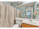 Bathroom with a single sink vanity, a large mirror, and a shower-tub combo with a striped curtain at 3906 N 297Th Cir, Buckeye, AZ 85396