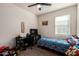 Bedroom with carpet, ceiling fan, window, and a gaming desk with a black rolling chair at 3923 S 244Th Dr, Buckeye, AZ 85326