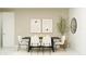 This stylish dining room features a black table, white chairs, a neutral rug, artwork, and a modern mirror at 4583 E French Rd, San Tan Valley, AZ 85143