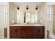 Elegant bathroom features double sinks with wood cabinets and a large mirror at 4931 N Woodmere Fairway -- # 1001, Scottsdale, AZ 85251