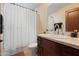 Well-lit bathroom featuring a vanity with dark wood cabinets and a shower with white curtain at 4931 N Woodmere Fairway -- # 1001, Scottsdale, AZ 85251