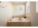 Bright bathroom featuring a soaking tub with travertine surround and natural light at 4931 N Woodmere Fairway -- # 1001, Scottsdale, AZ 85251