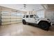 Spacious garage with a parked Jeep and ample space for storage at 4931 N Woodmere Fairway -- # 1001, Scottsdale, AZ 85251