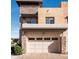 Beige two car garage beneath a two story stucco and stone building with a brick paver driveway at 4931 N Woodmere Fairway -- # 1001, Scottsdale, AZ 85251