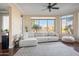 Bright living room with large bay window, hardwood flooring, and a comfortable white couch at 4931 N Woodmere Fairway -- # 1001, Scottsdale, AZ 85251