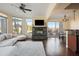 Open-concept living area with fireplace, dark wood floors, and sliding glass doors to a balcony at 4931 N Woodmere Fairway -- # 1001, Scottsdale, AZ 85251