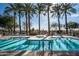 Stunning pool area with inviting blue water, lined with lounge chairs and lush palm trees at 4931 N Woodmere Fairway -- # 1001, Scottsdale, AZ 85251