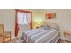 Neutral bedroom featuring wood laminate flooring, a gold metal bed frame, and window with orange curtains at 537 S Delaware Dr # 115, Apache Junction, AZ 85120