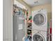 Laundry room with white washer and dryer, hot water tank, and storage shelves at 537 S Delaware Dr # 115, Apache Junction, AZ 85120