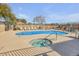 Community pool and spa area with several lounge chairs, umbrellas and mature landscaping at 537 S Delaware Dr # 115, Apache Junction, AZ 85120