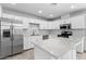 Modern kitchen features stainless steel appliances, white cabinets, and a center island with a quartz countertop at 5919 W Villa St, Phoenix, AZ 85043