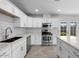 Bright kitchen with stainless appliances, white cabinets, and tiled backsplash offers ample counter space at 5919 W Villa St, Phoenix, AZ 85043