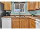 Bright kitchen sink featuring wood cabinets, stainless-steel fixtures, and view to backyard at 6329 E Dodge St, Mesa, AZ 85205