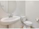 Bathroom with pedestal sink and toilet with tiled floors at 6336 S Granite St, Gilbert, AZ 85298