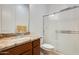 Bathroom with shower featuring modern glass doors, granite countertops and wood cabinets at 6336 S Granite St, Gilbert, AZ 85298