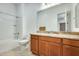 Bathroom featuring a shower-tub combo, granite countertops and wood cabinets at 6336 S Granite St, Gilbert, AZ 85298