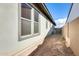 Exterior view of a house, featuring windows with dark trim and neutral siding at 6336 S Granite St, Gilbert, AZ 85298