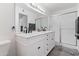 Bathroom featuring a double vanity, a large mirror, updated lighting, and a glass-enclosed shower for a modern touch at 6345 N 49Th Ave, Glendale, AZ 85301