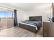 Bedroom featuring a bed with blue and gray striped sheets, dark wood furniture, and a sliding glass door to the outside at 6345 N 49Th Ave, Glendale, AZ 85301