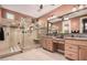 Well-lit bathroom with granite countertops, dual sinks, and a glass-enclosed shower at 65 W Cucumber Tree Ave, San Tan Valley, AZ 85140