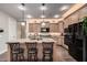 Well-lit kitchen featuring a center island with bar stool seating, pendant lighting, and ample counter space at 65 W Cucumber Tree Ave, San Tan Valley, AZ 85140