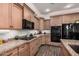 Well-equipped kitchen featuring granite countertops, wood cabinets, and modern appliances at 65 W Cucumber Tree Ave, San Tan Valley, AZ 85140